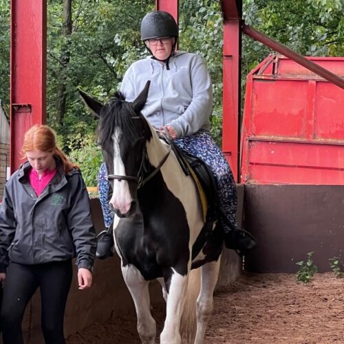 PHOTO-2024-11-04-10-30-00 2 Sophie riding a black and white horse.